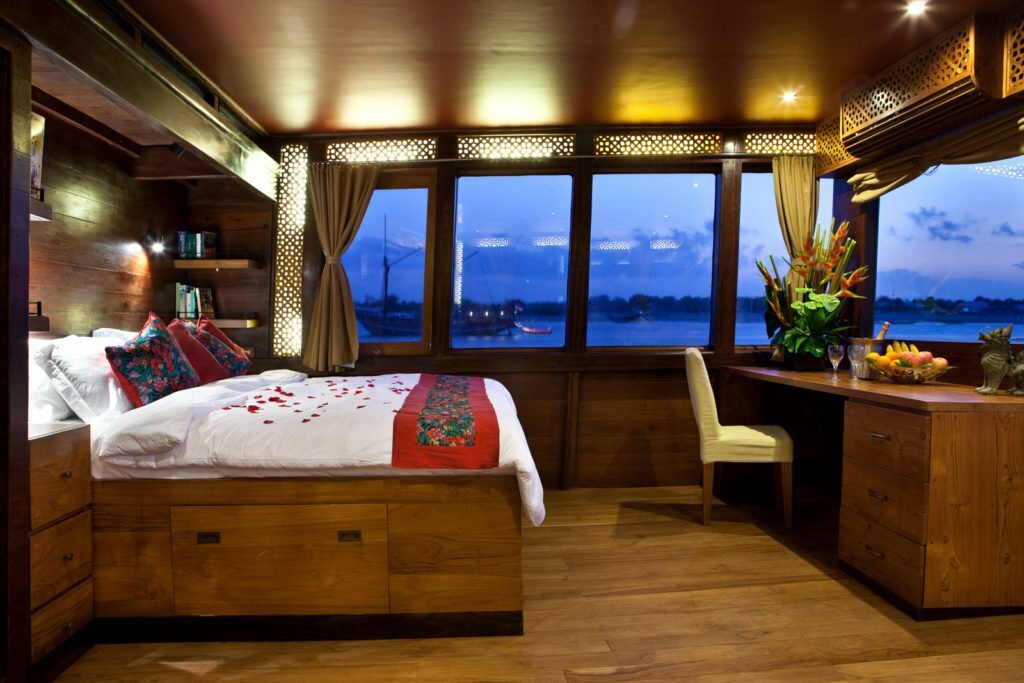 El Aleph cruise master cabin with comfy master bed, working table, and chair.